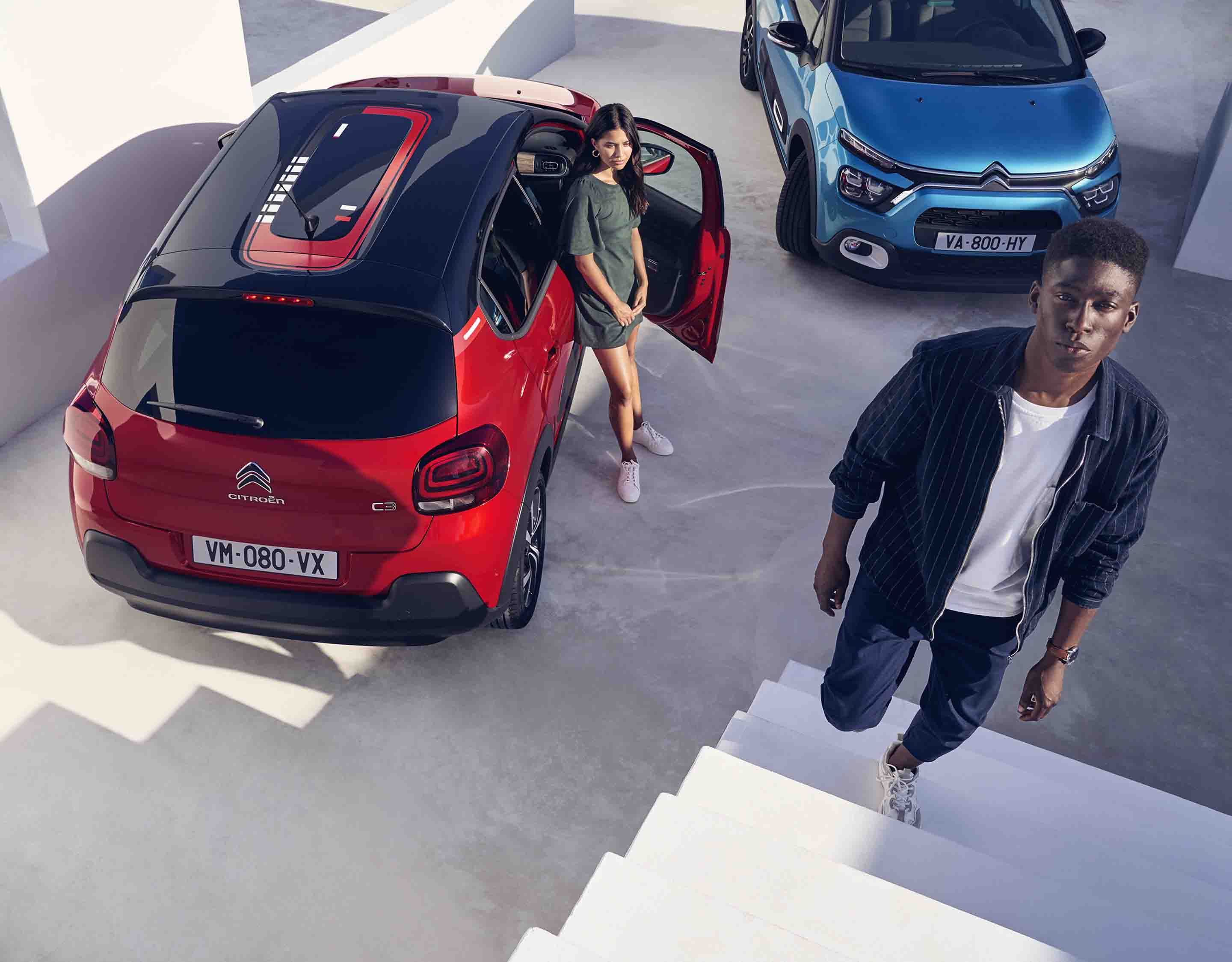 Дівчина біля Citroen C3 червоного кольору й хлопець біля Citroen C3 синього кольору