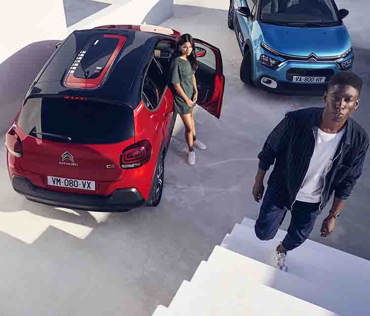Дівчина біля Citroen C3 червоного кольору й хлопець біля Citroen C3 синього кольору