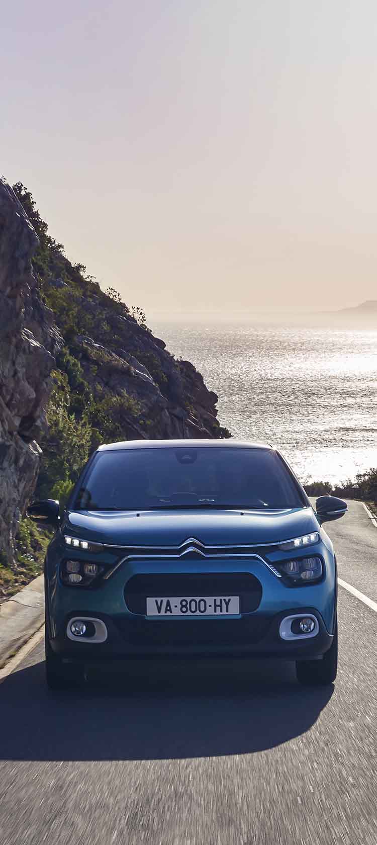 Citroen C3 їде по трасі біля моря, вигляд спереду